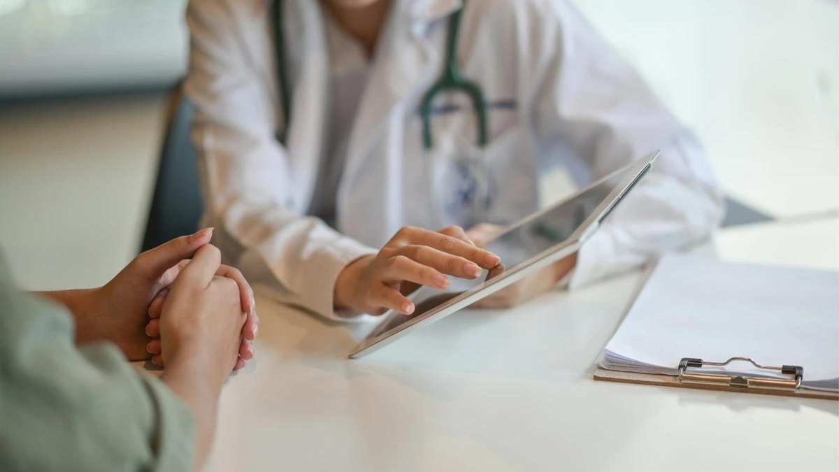 Doctor discussing healthcare options with a patient at a clinic table