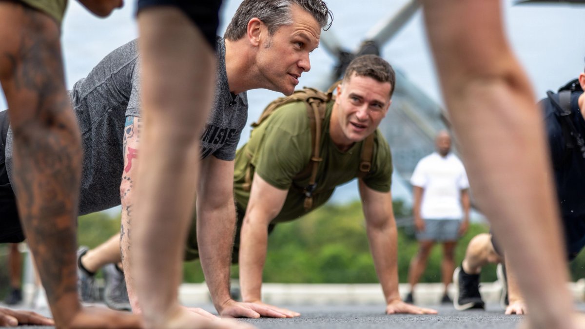 Sec'y Hegseth does push-ups with service members.
