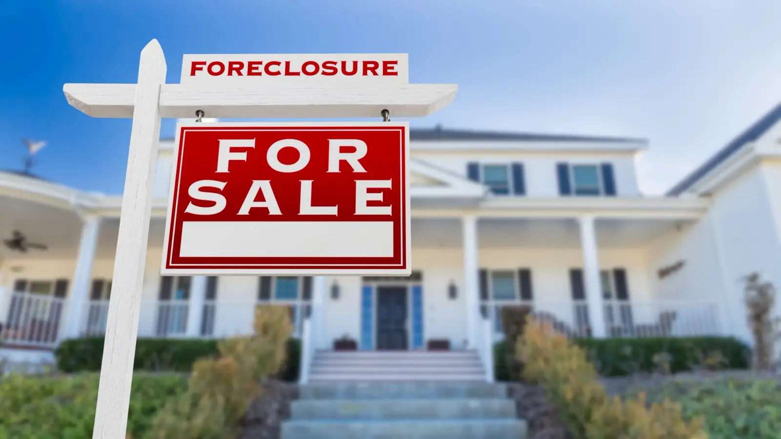 Close-up picture of a Foreclosure For Sale sign in front of a house.
