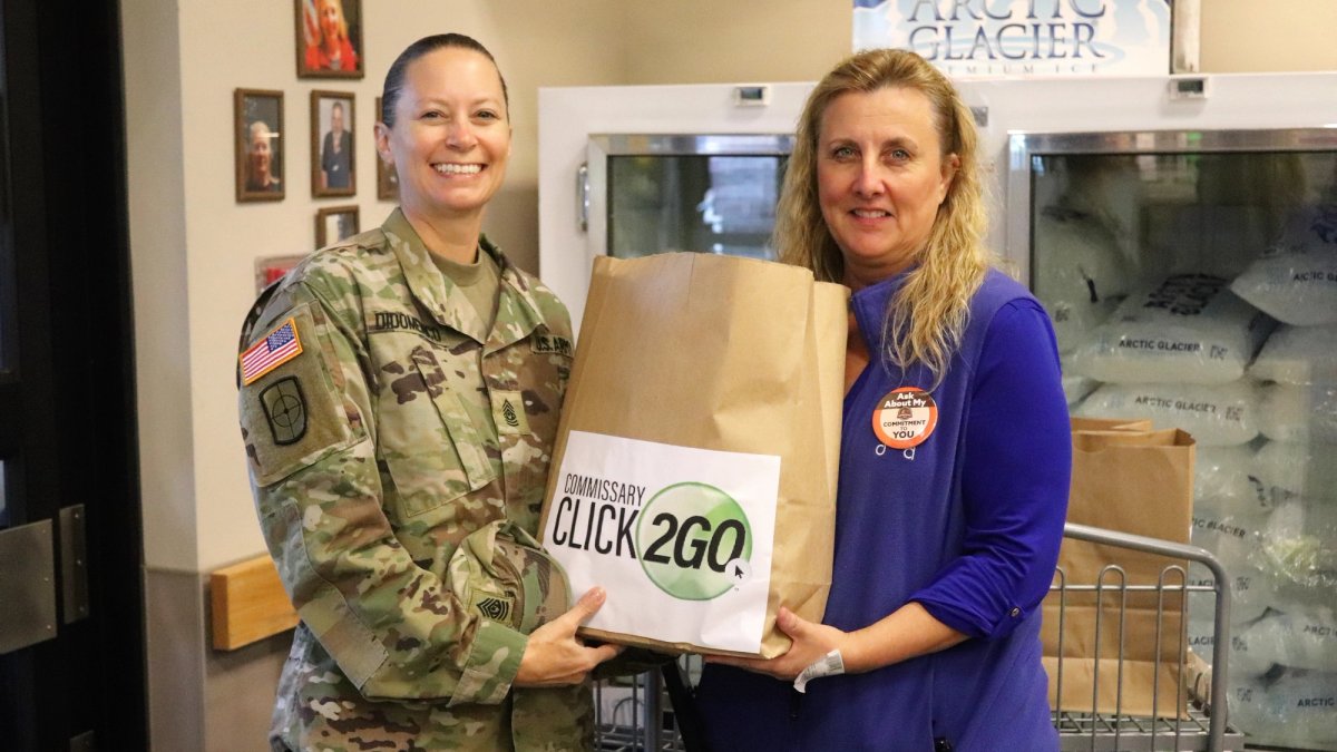 Two women holding a Click2Go shopping bag.