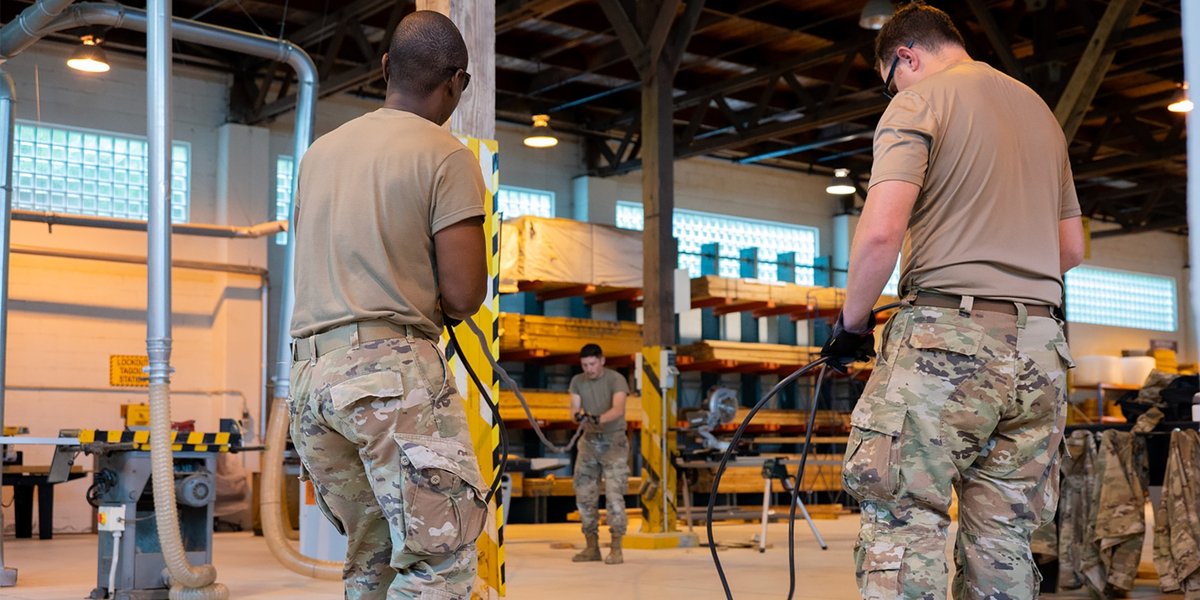 Three soldiers coil wire in preparation for a special assignment.