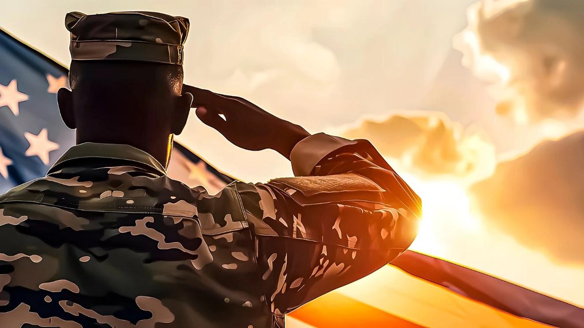 Soldier in camouflage saluting American flag at sunset