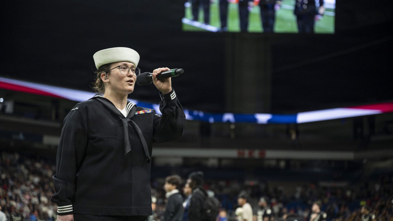 Woman sings the National Anthem.