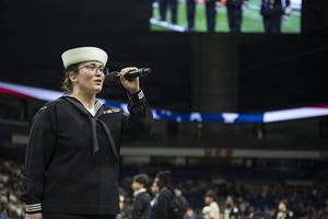 Woman sings the National Anthem.