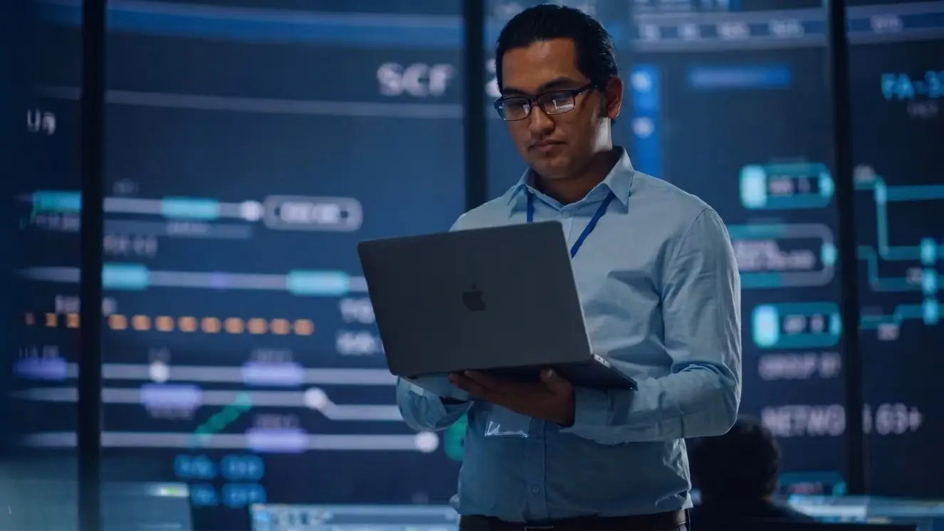 A cybersecurity analyst works on a laptop.