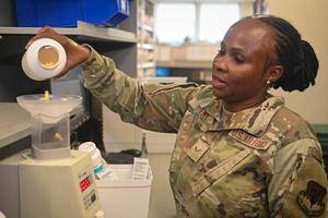  A uniformed pharmacist pours pills into a pill counter.