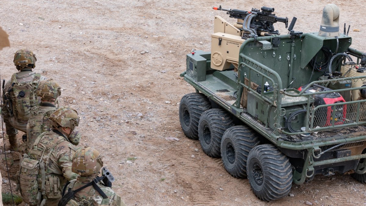 Soldiers watch the movement of an autonomous tank.