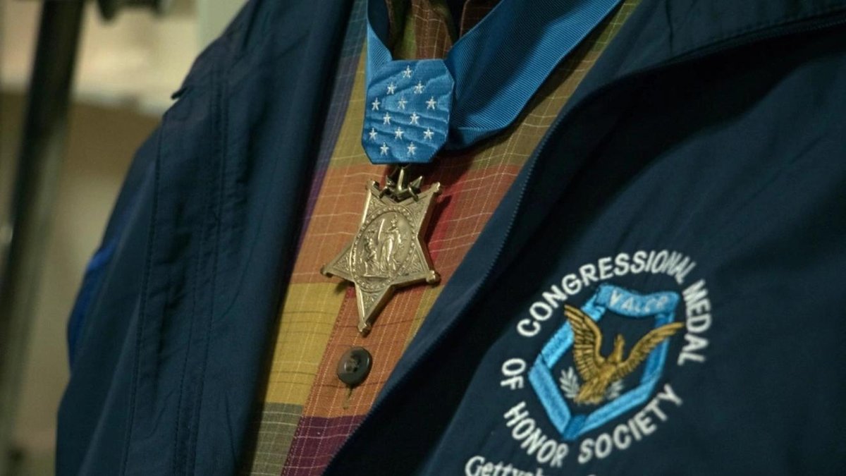 Medal of Honor worn on plaid shirt under Congressional Medal of Honor Society jacket
