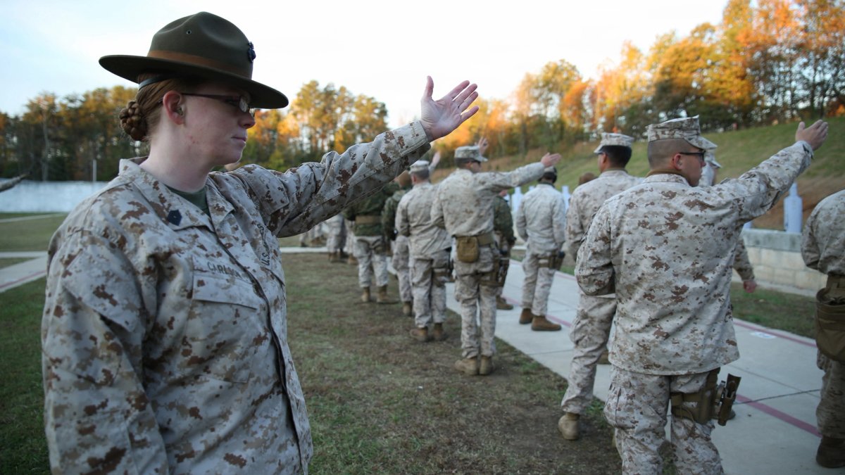 Female soldier gestures to soldiers during a training.