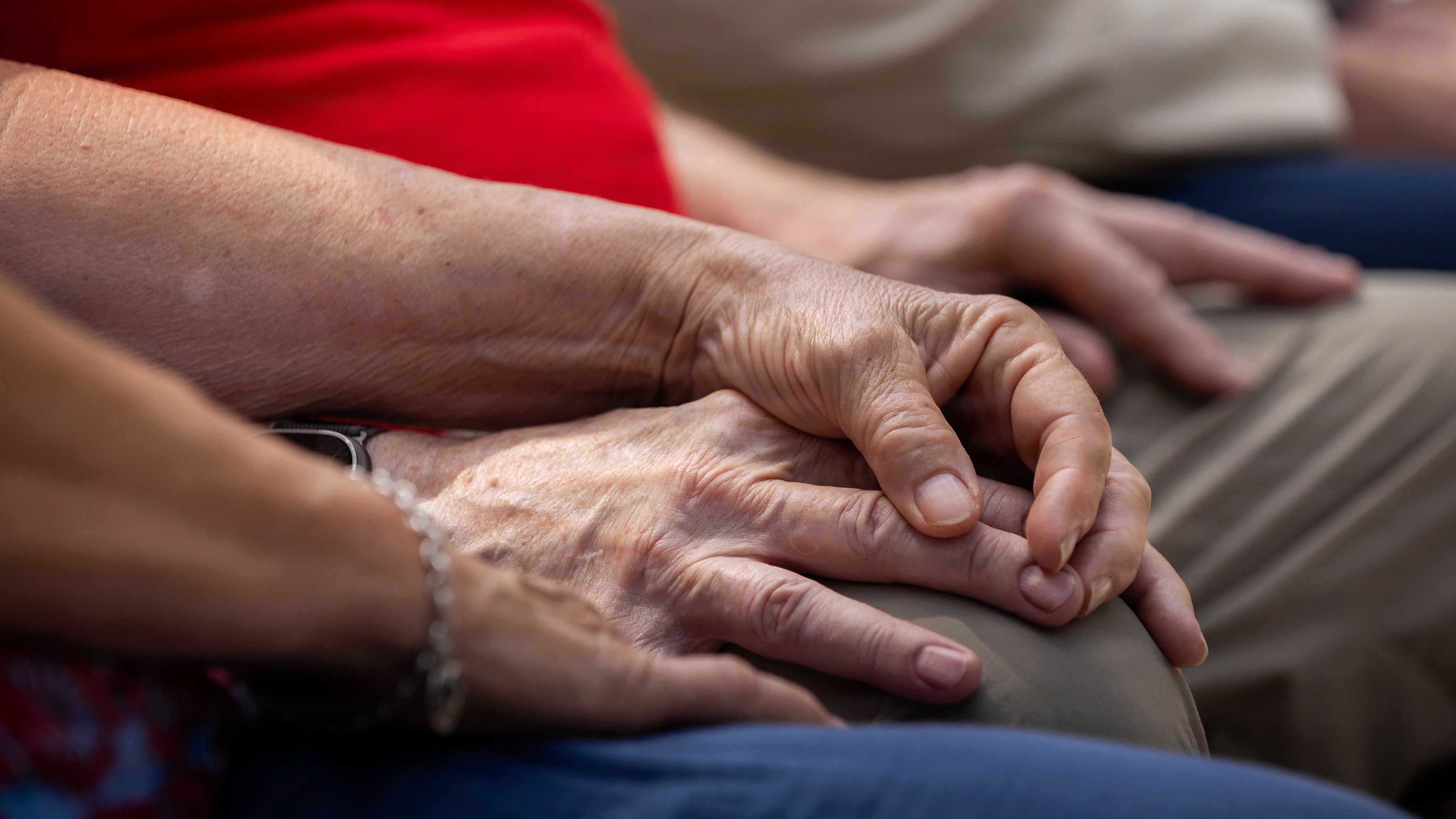 Close-up of holding hands of couple at an event.