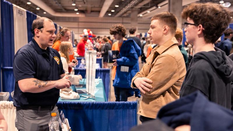 Aviation Boatswain's Mate (Fuel) 1st Class Daniel Dunlevy, a recruiter assigned to Navy Talent Acquisition Group Pittsburgh, engages with students attending the National Association for College Admissions Counseling National College Fair.