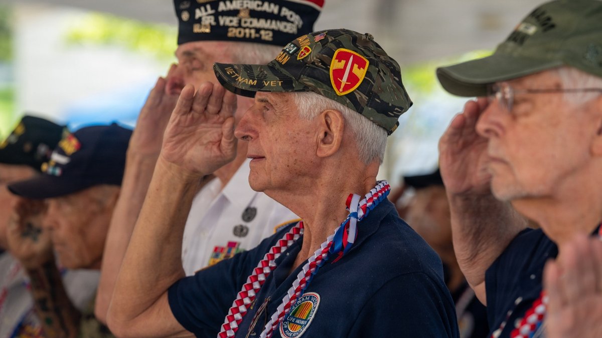 Veterans salute during a ceremony.
