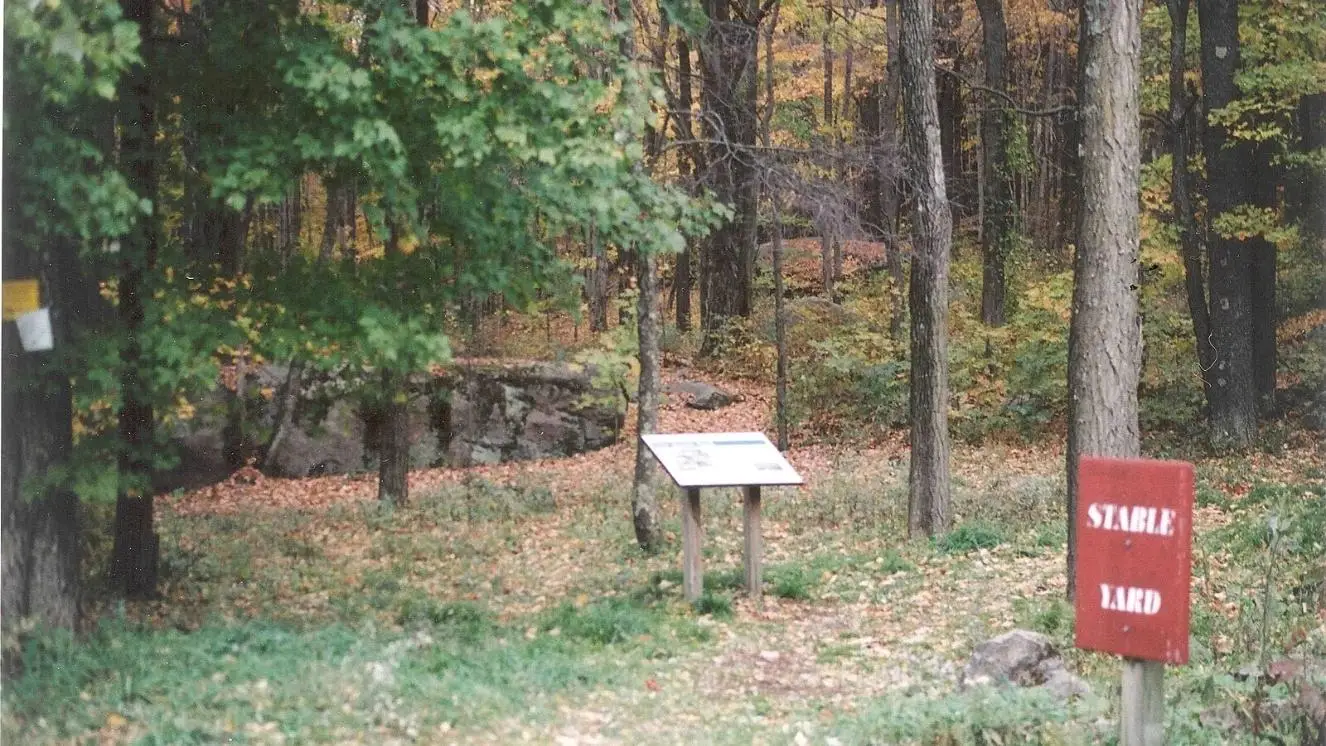 Civil War trailhead with information sign and wooded path in autumn forest