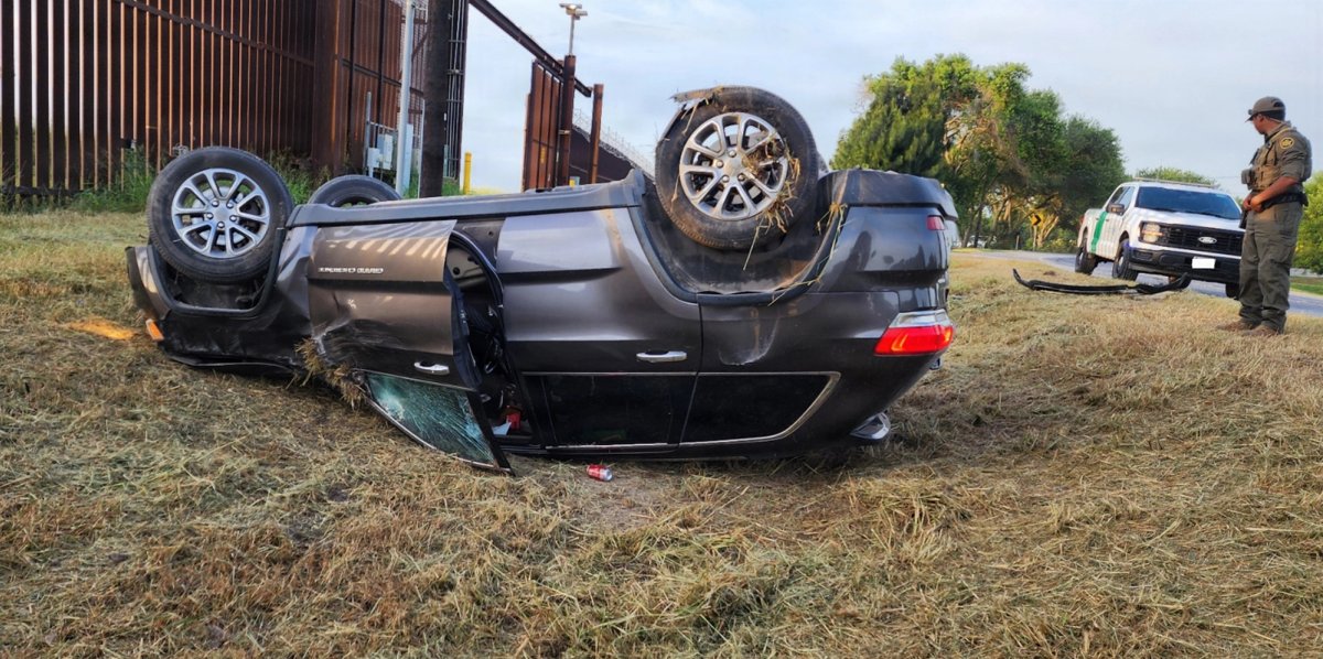 A soldier inspects an overturned vehicle.
