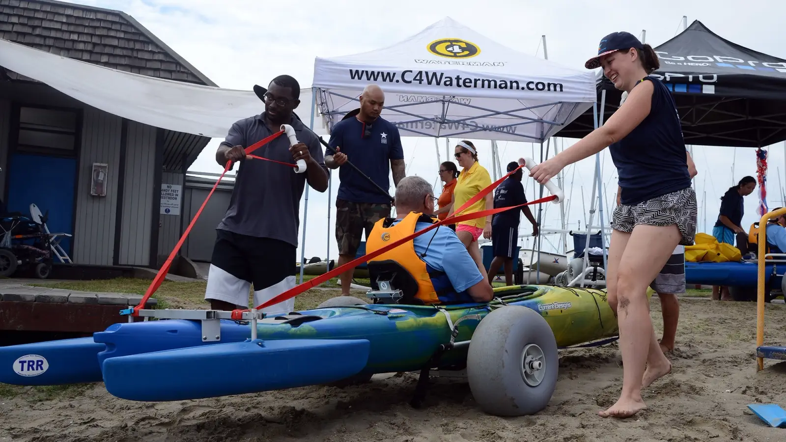Volunteers adjust equipment for adaptive surfing.