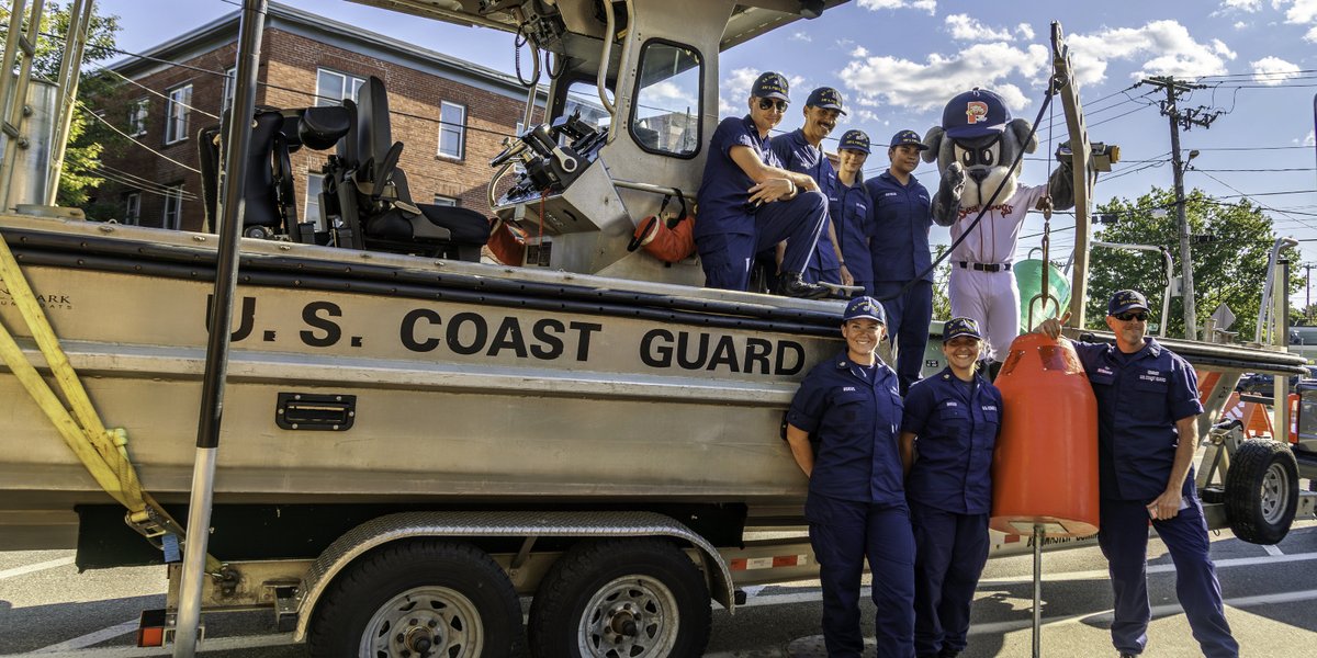 Members of the U.S. Coast Guard Aids to Navigation Team (ANT) pose with the Portland Sea Dogs mascot next to their 26-foot Trailerable Aids to Navigation Boat (TANB) at Hadlock Field. The event showcased Coast Guard missions and highlighted recruiting efforts.