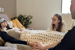  A therapist holds the hand and comforts a patient.