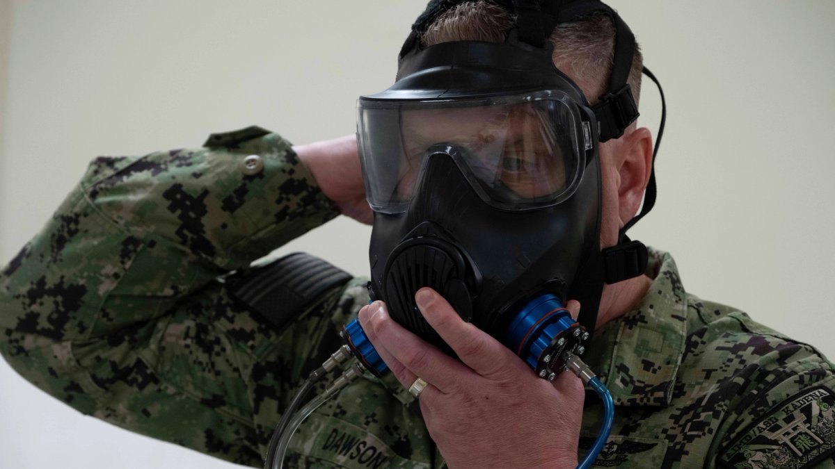 Close-up of a soldier applying a gas mask.
