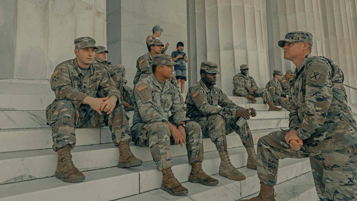 Group of soldiers sitting on the steps of the Lincoln Memorial.