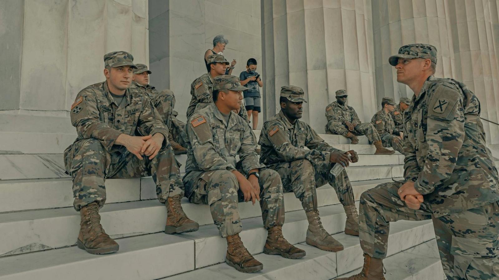 Group of soldiers sitting on the steps of the Lincoln Memorial.