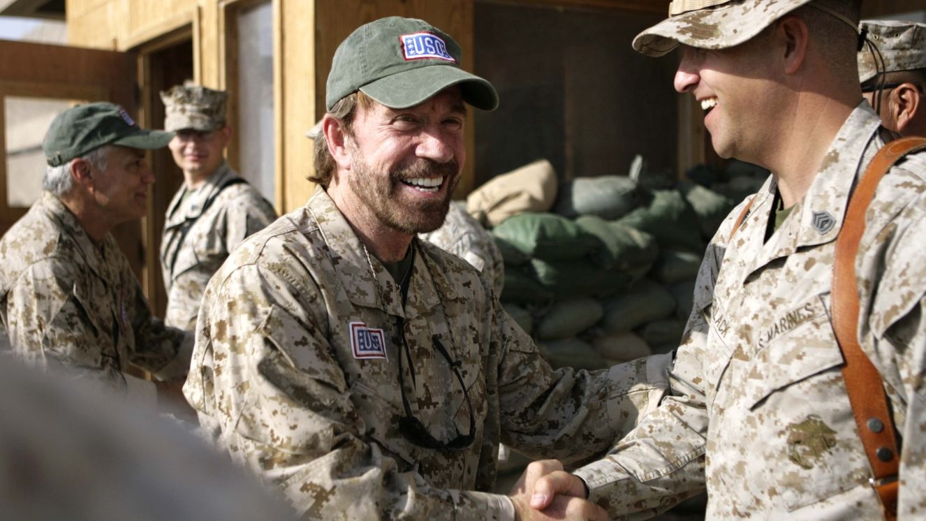 Chuck Norris shakes a man's hand.
