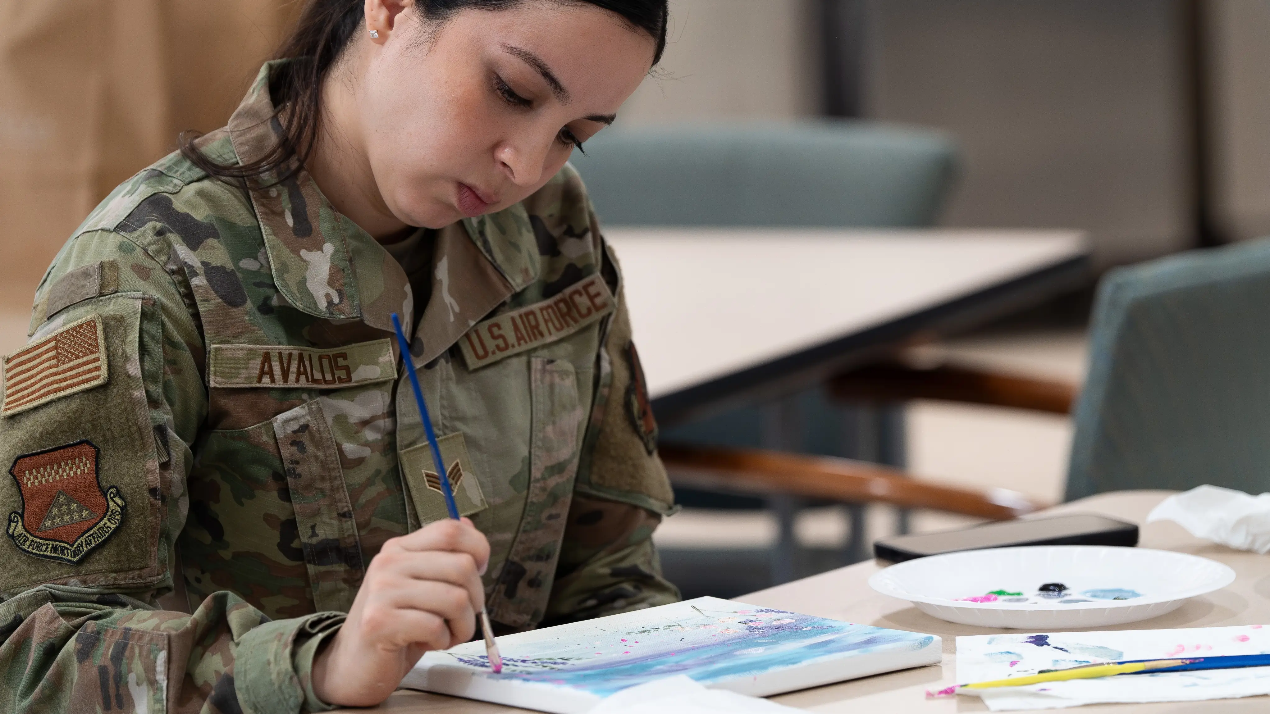 A female soldier paints in an art therapy session.