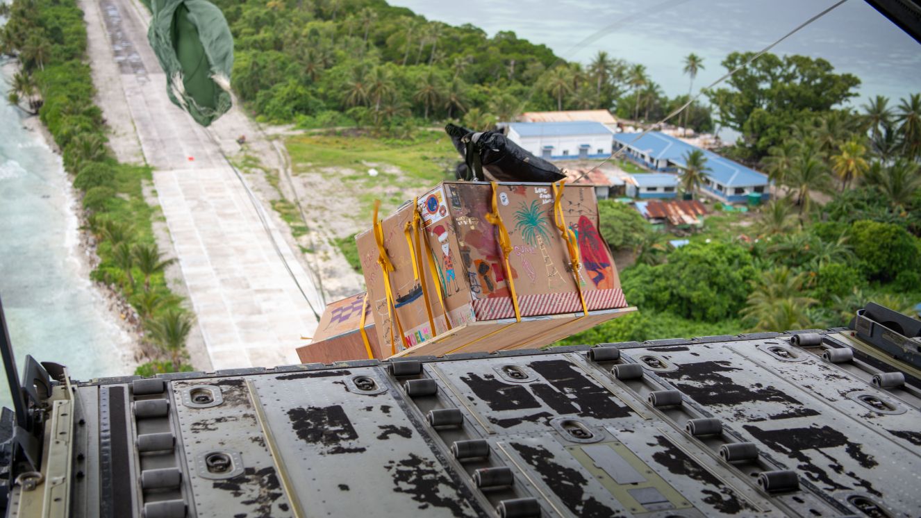 Bundles drop from a U.S. Air Force C-130J Super Hercules during Operation Christmas Drop 2024 above Ta, an Island in the Federated States of Micronesia.