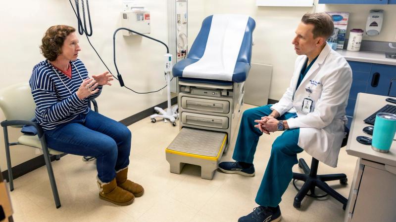Sarah Thompson discusses her progress at her post-op appointment with U.S. Navy Capt. (Dr.) Michael Cirivello, chief of Neurosurgery at Walter Reed National Military Medical Center after a spinal fusion procedure to alleviate chronic back pain.