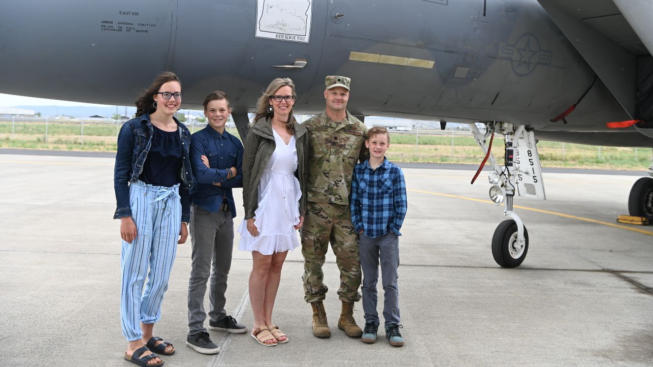 Kamron Bouma poses with his family underneath his artwork, seen here applied to a U.S. Air Force F-15C Eagle at Kingsley Field.
