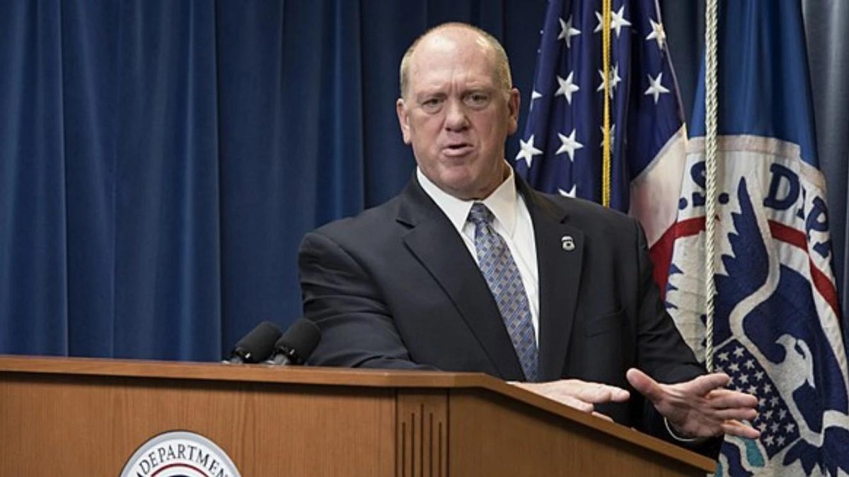Tom Homan speaking at podium with Homeland Security seal in background