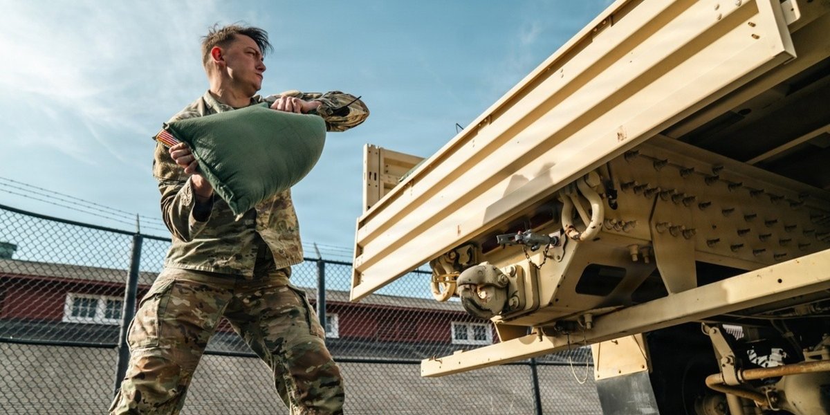 Man lifting a bag onto a truck.