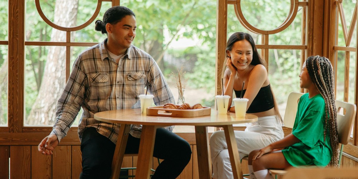A family of three eats at a table in a restaurant.