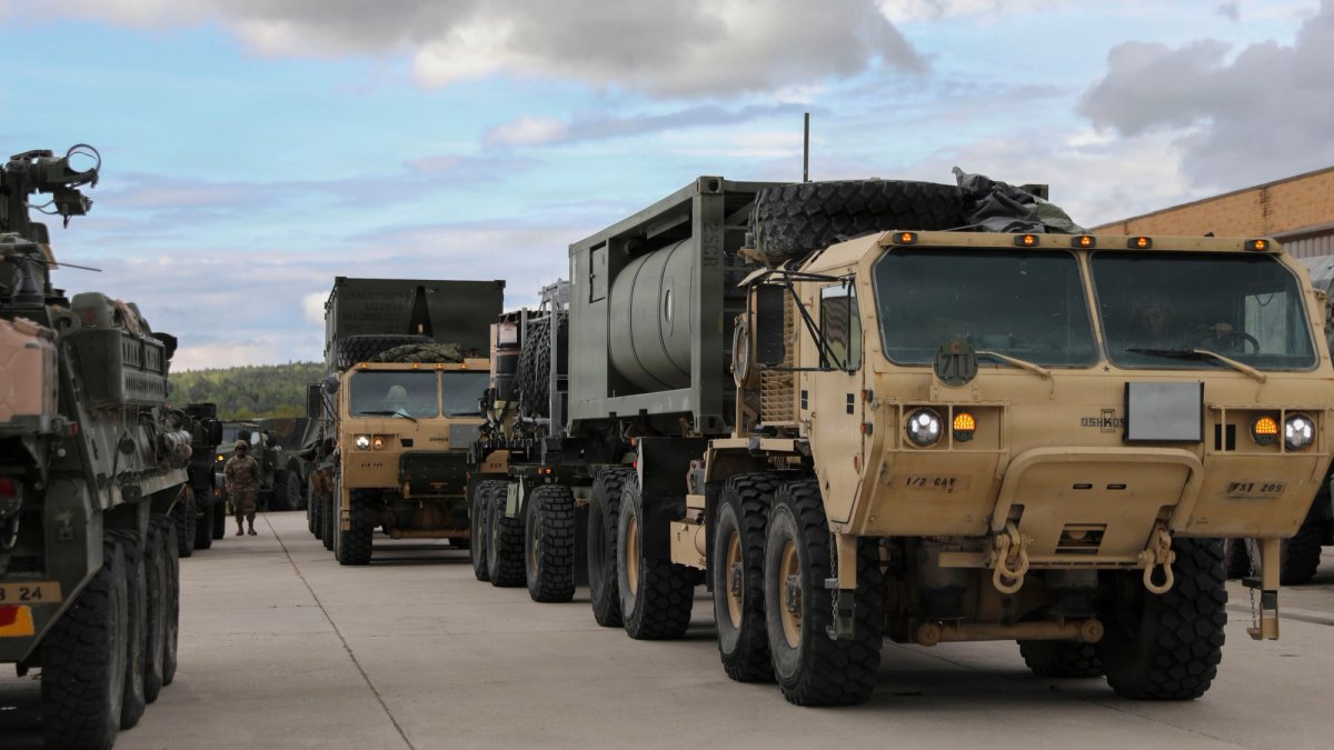 Heavy-duty military trucks move in formation.