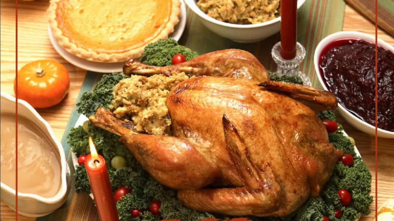 Thanksgiving dinner table with roasted turkey, stuffing, and cranberry sauce