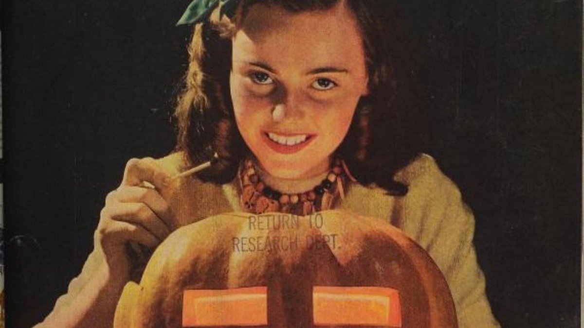 Smiling woman carving a jack-o'-lantern during World War 2 rationing.