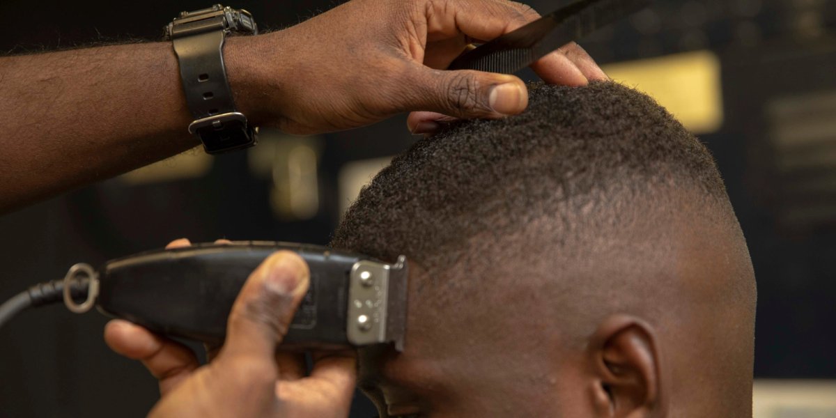 An African-American soldier gets a haircut with clippers.