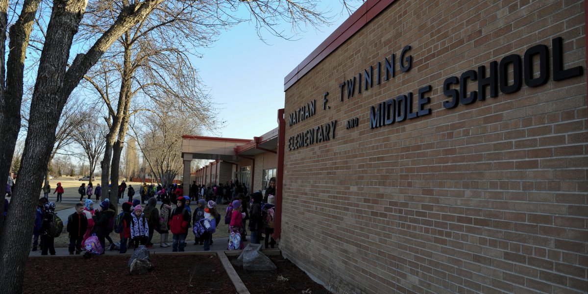 Students wait for the first bell to ring outside Nathan Twining Elementary and Middle School April 6, 2015, on Grand Forks Air Force Base, N.D. Twining hosts grades K-8 for children of military families. (U.S. Air Force photo by Airman 1st Class Ryan Sparks/released)