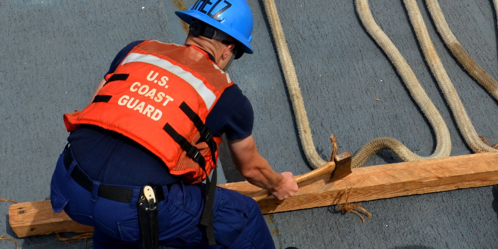 Coast Guard service member working with an axe.