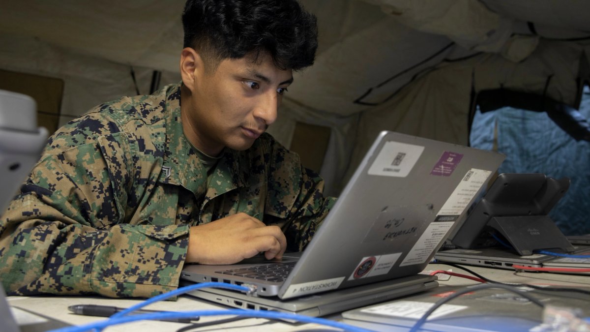 Soldier works on cell registration on his laptop.