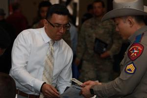 Man talks to a State Trooper at a job fair.