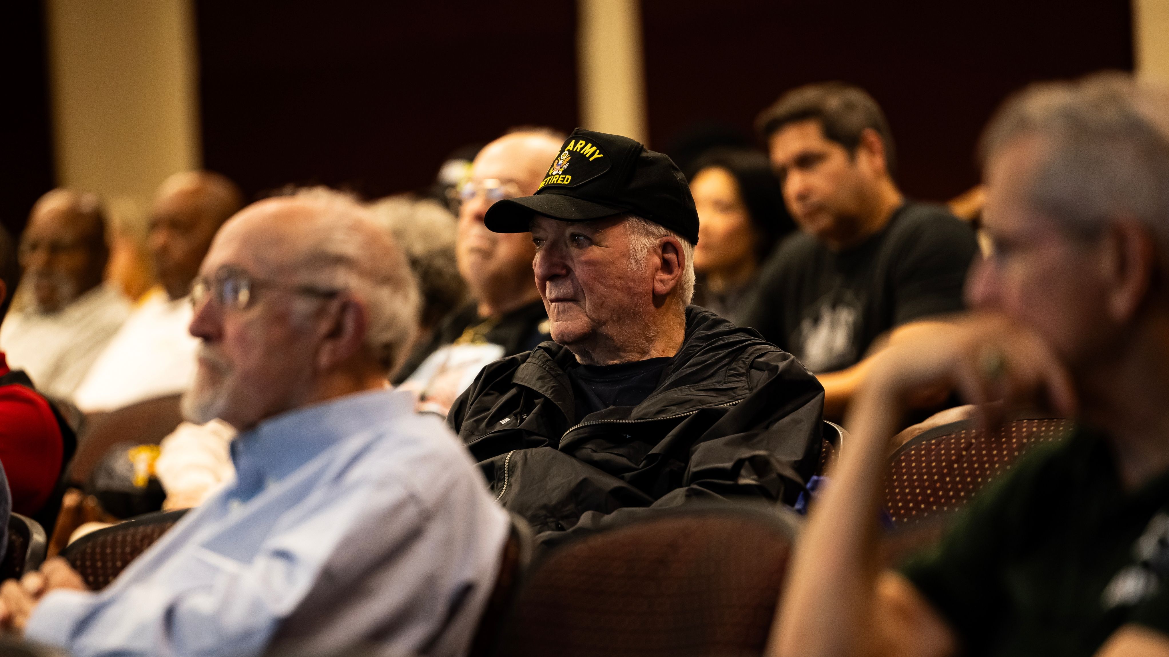 A group of vets sit in an audience.