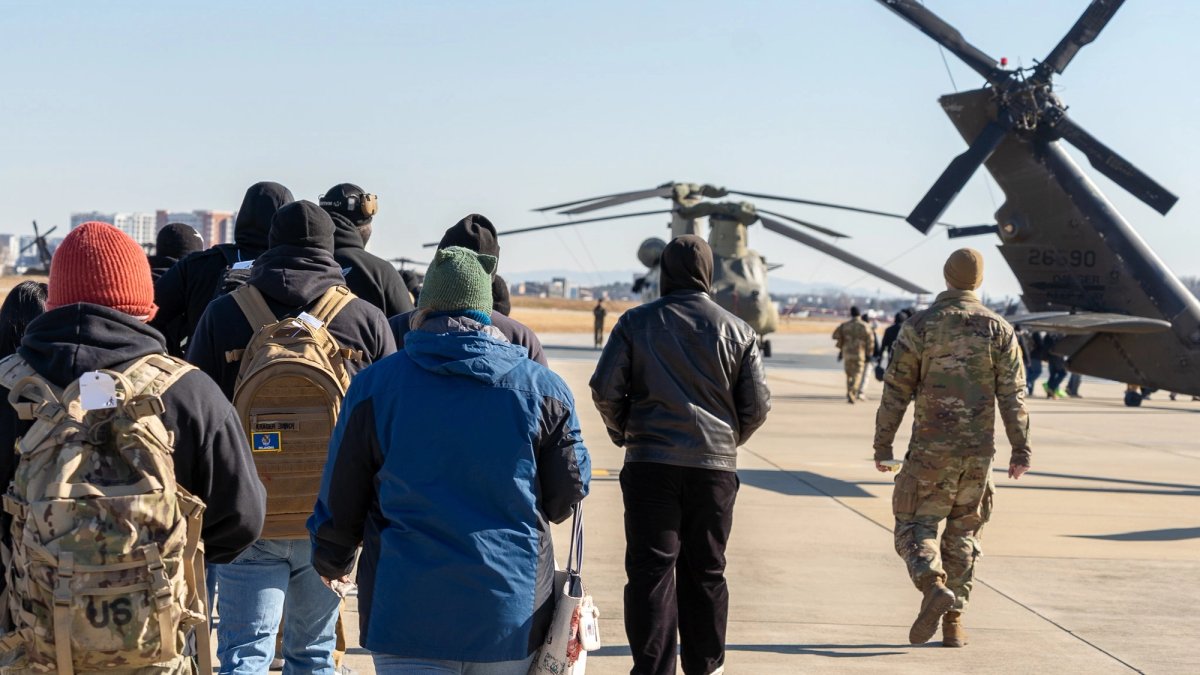 Families walk to military choppers in an evacuation exercise.