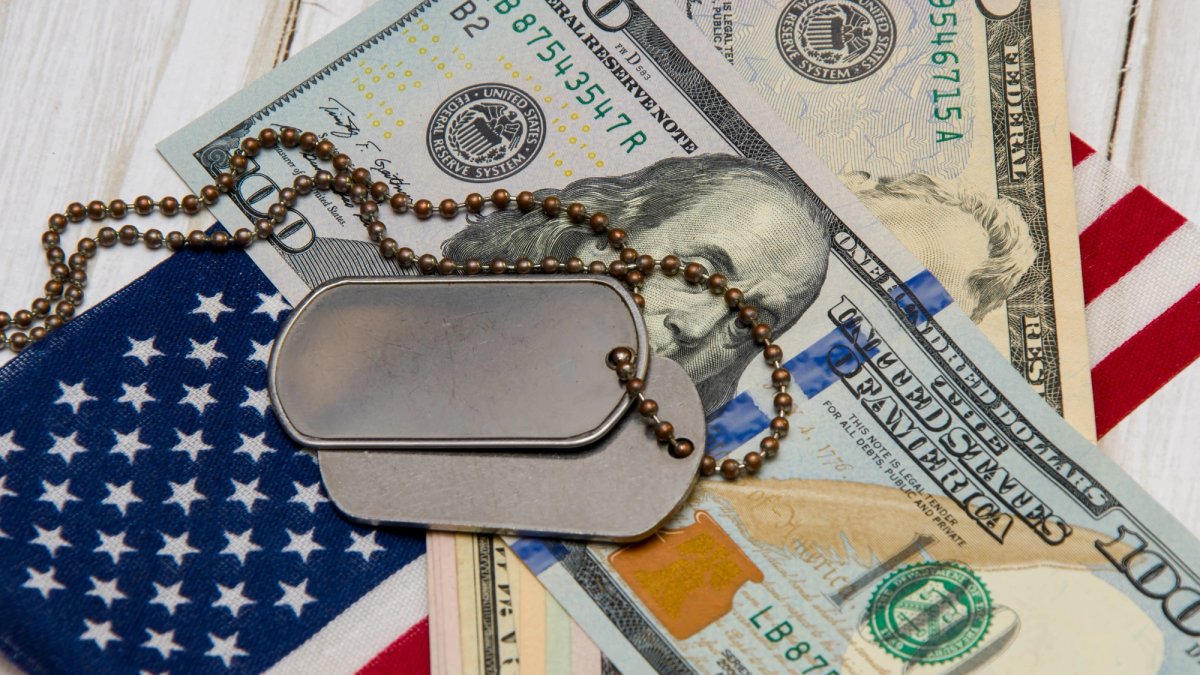 Still Life photo illustration of dogtags, cash and American flag.