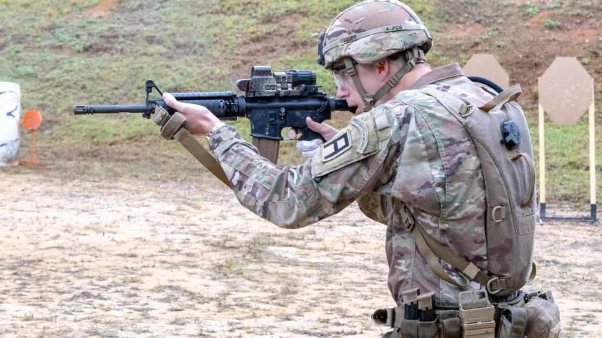 Army soldier aiming M4 rifle during training exercise on outdoor range