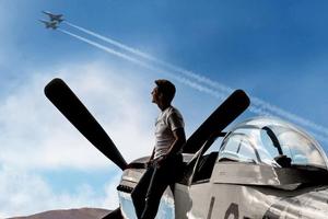 Tom Crusie near a plane, looking at the sky.