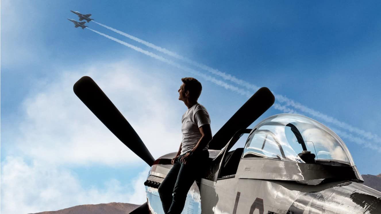 Tom Crusie near a plane, looking at the sky.