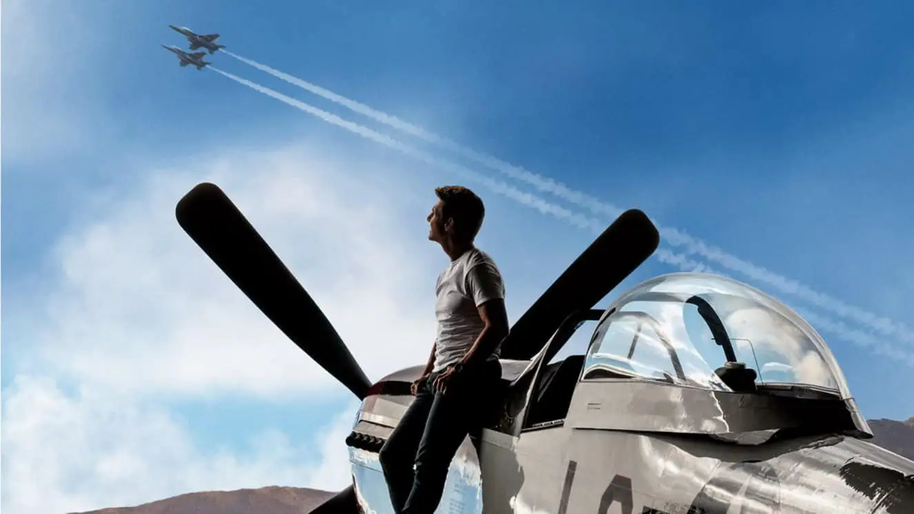 Tom Crusie near a plane, looking at the sky.