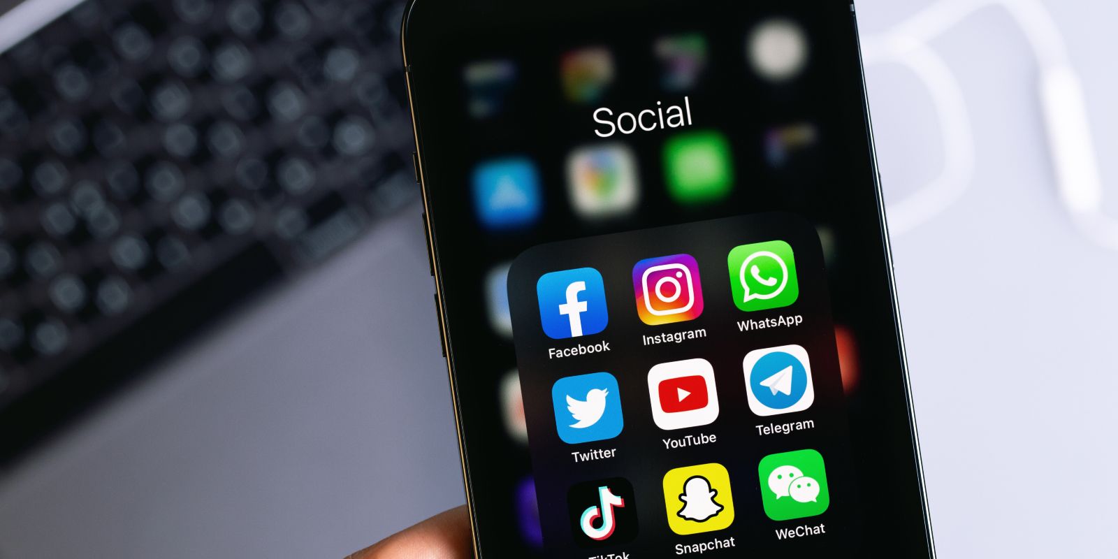 Social media mobile apps (Facebook, Instagram, WhatsApp, Twitter, YouTube, Telegram, TikTok, Snapchat) on and iPhone screen, in light of the new Navy social media guidelines.