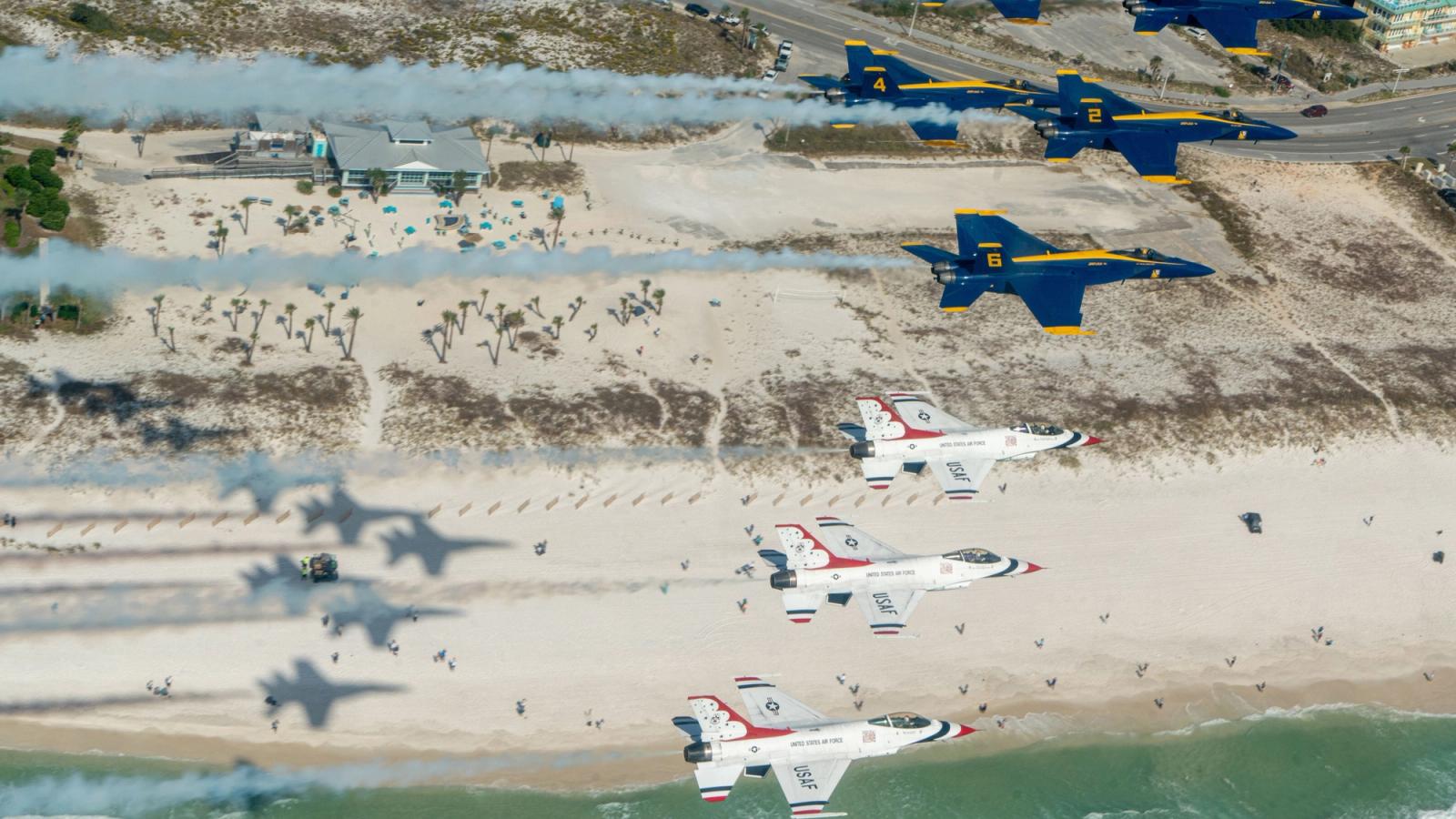 Blue and white Navy jets fly in formation.