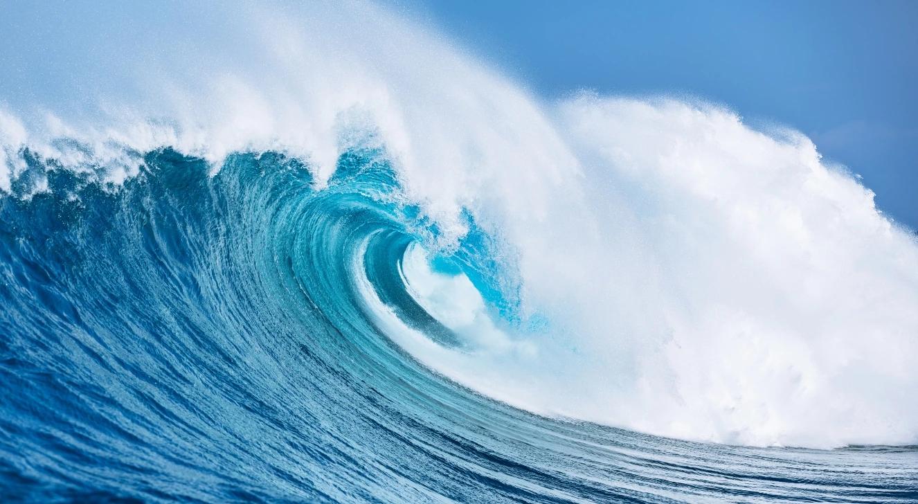 Large ocean wave cresting under blue sky, symbolizing WWII Project Seal tsunami bomb experiment.